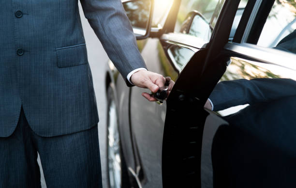 Well dressed man opening a car door
